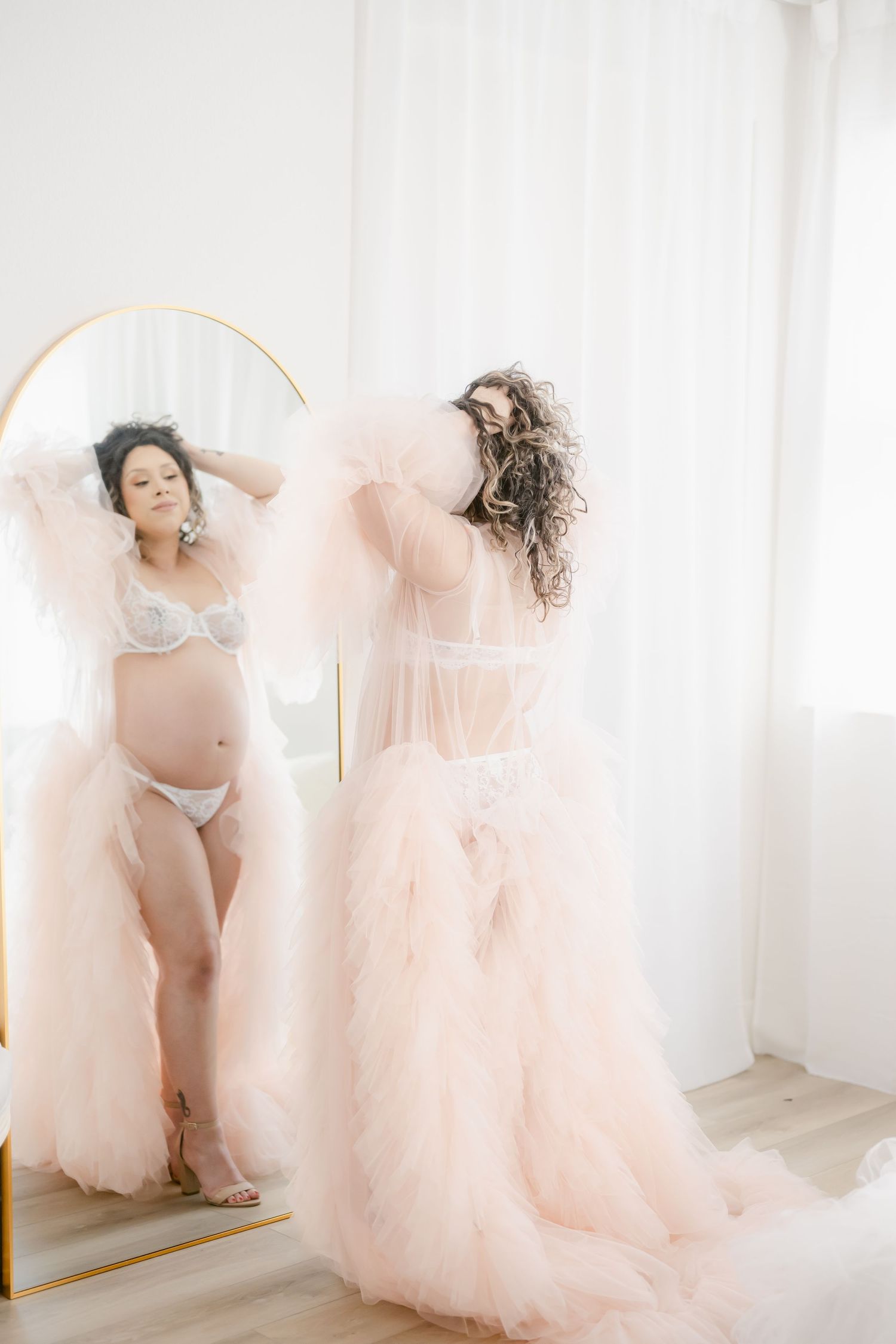Artistic boudoir portrait with mirror reflection and flowing peach tulle dress.