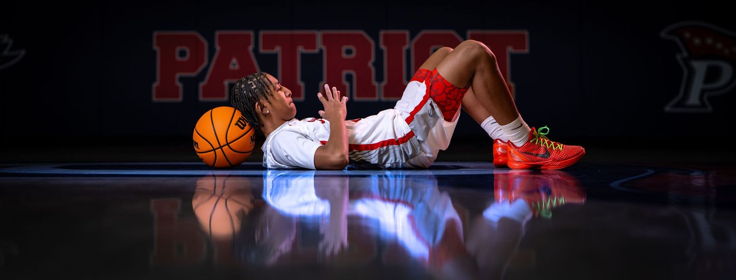Basketball player in white and red uniform lies on illuminated court floor with basketball. sports Media day