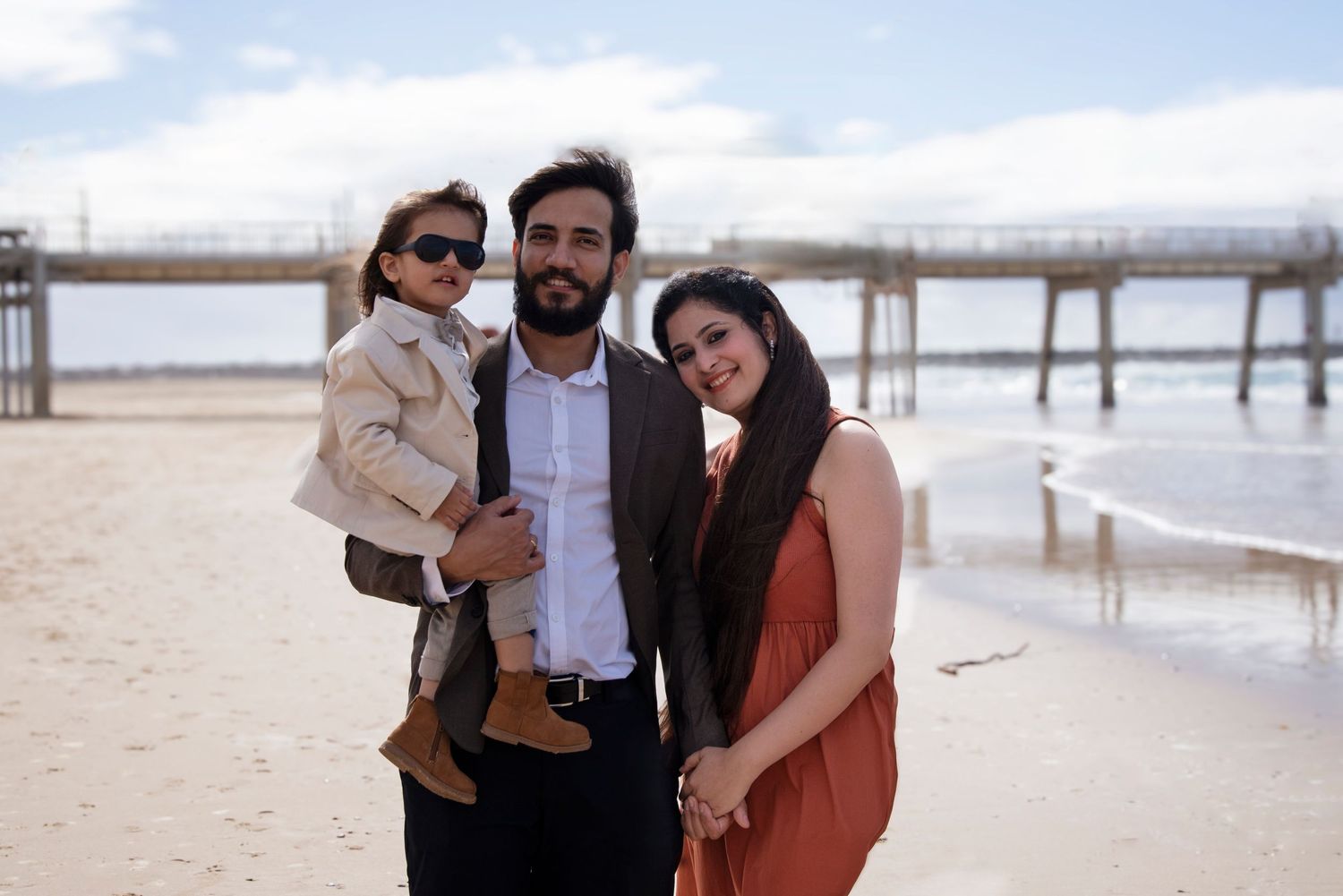 family photo of parents with their son at the spit Gold Coast with the pier in the background