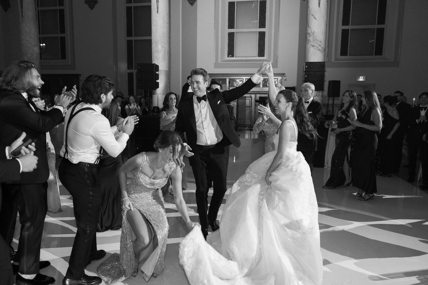 Two grooms sharing a romantic kiss at a stylish bar in black and white wedding photography.
