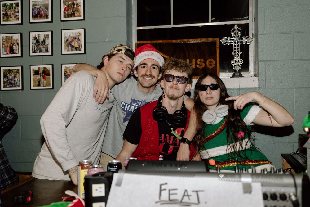 Friends pose together at a holiday party with festive decorations.