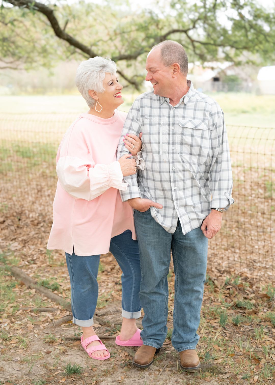 Grandparents walking together outdoors sharing a laugh.