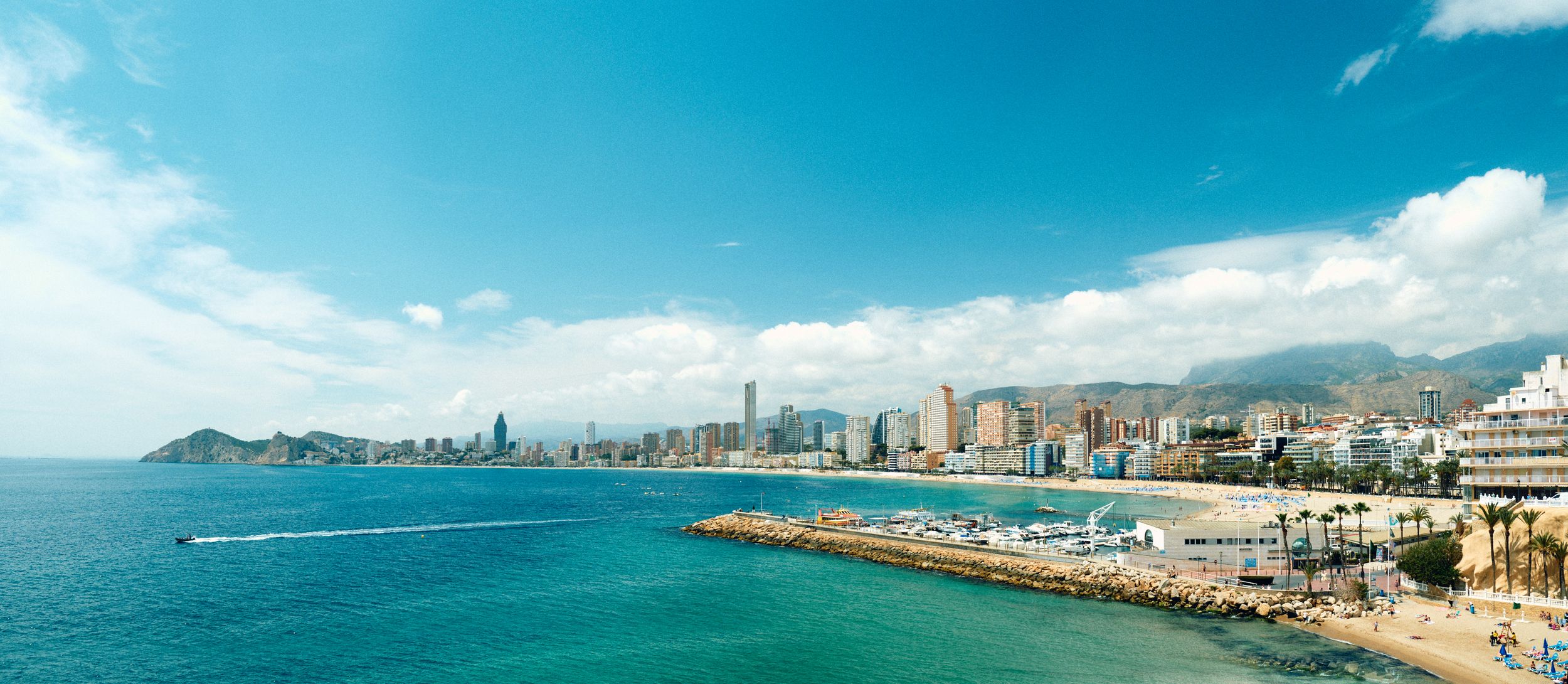 Panoramic coastal view of Benidorm's skyline and beach along Mediterranean sea.