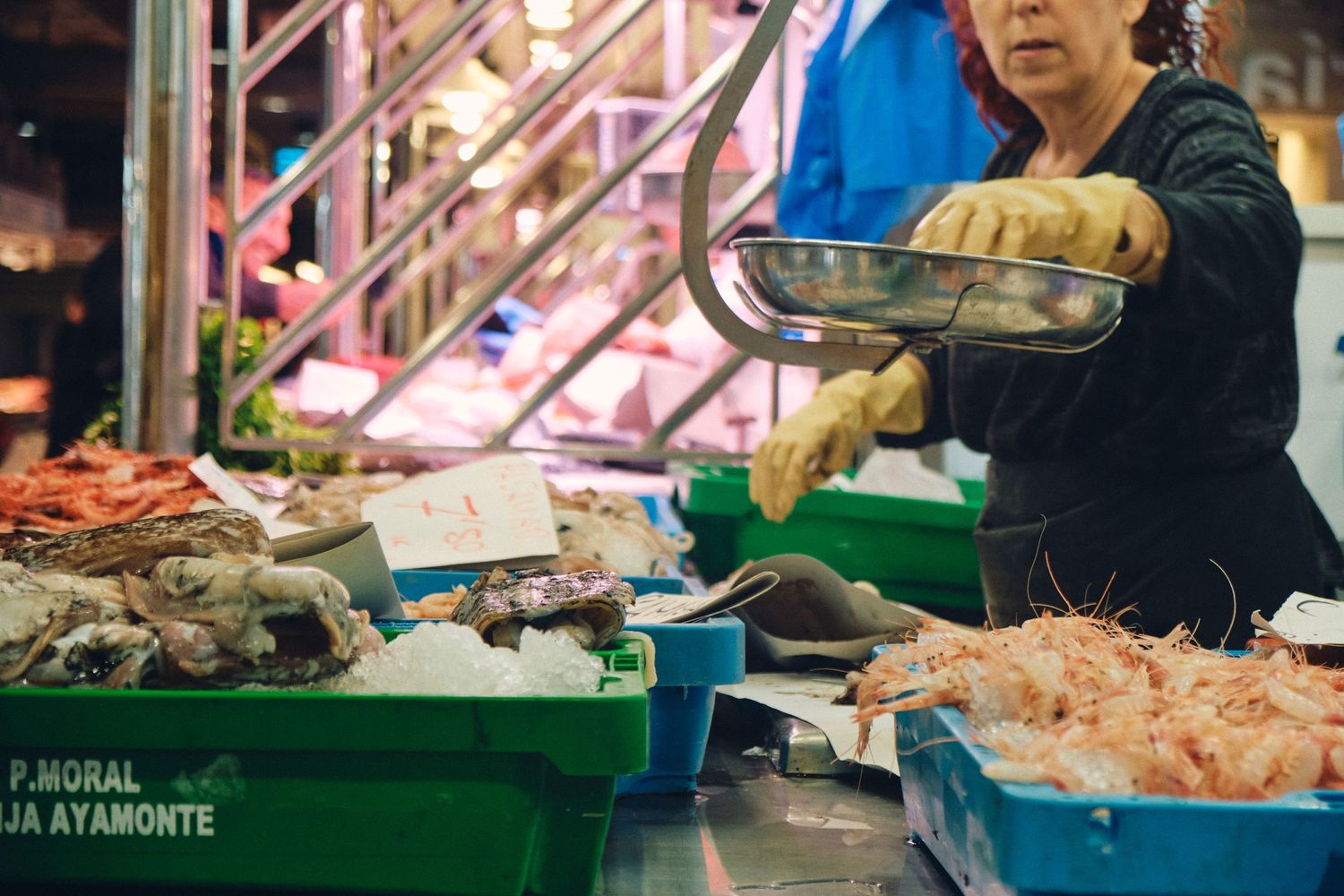 Vendor displaying fresh seafood at bustling market counter.