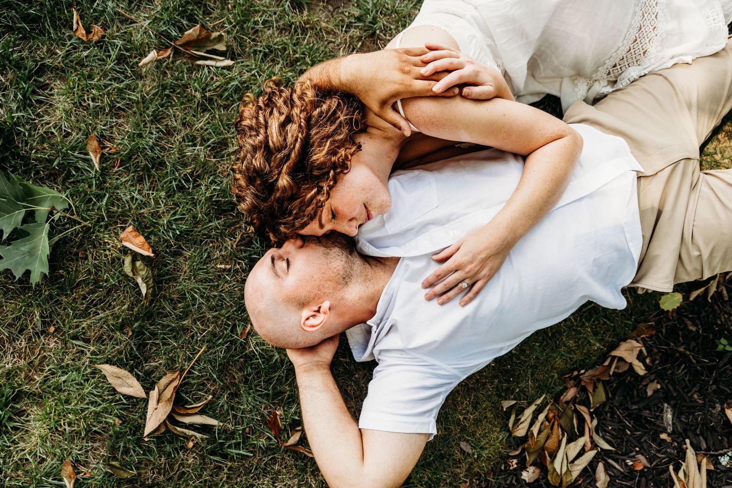 Couple snuggle in the grass