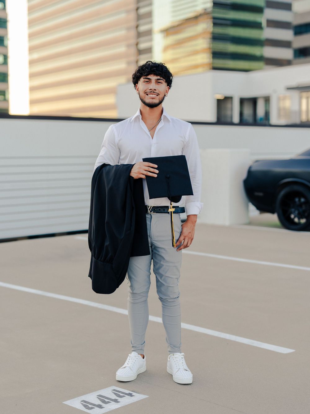 Professional attire with black blazer and folder against urban architecture background.