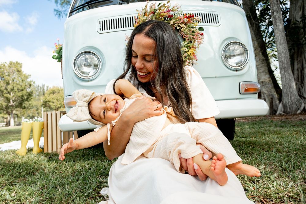 Family photoshoot with vintage Volkswagen bus in natural outdoor setting.