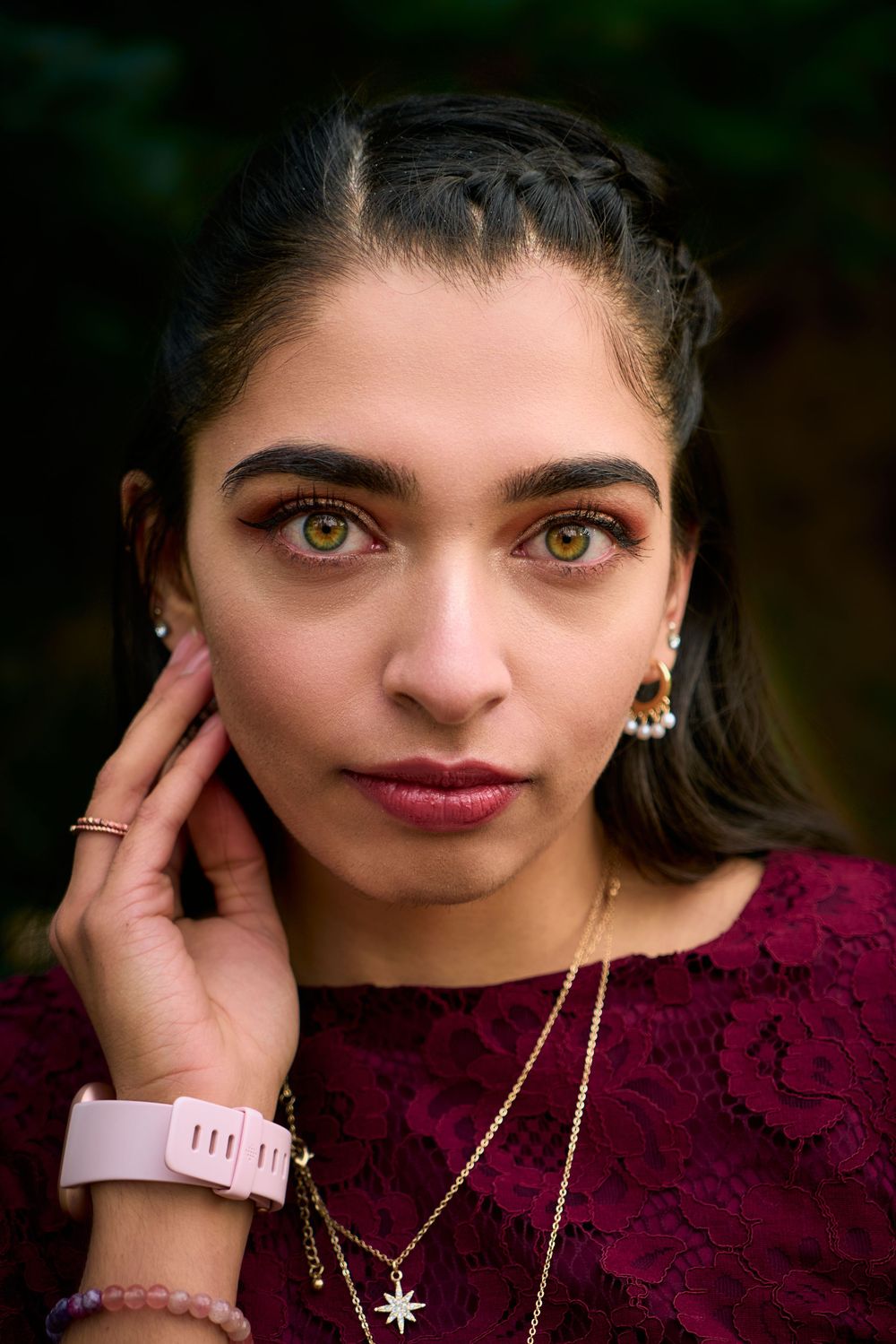 A series of close-up portraits showing eyes, lips, and jewelry against a dark background with burgundy lace details.