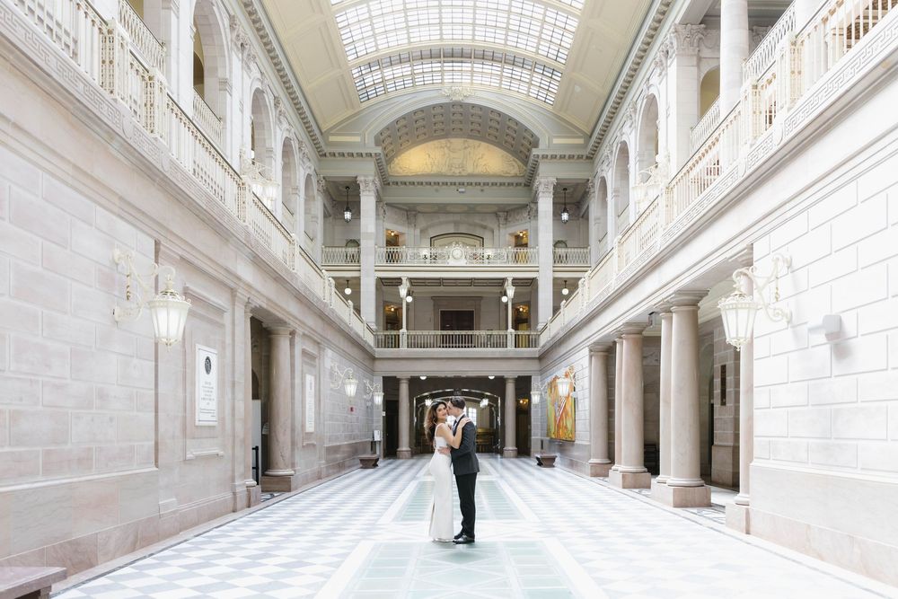 Grand interior hallway with vaulted glass ceiling and classical columns creating symmetrical perspective.