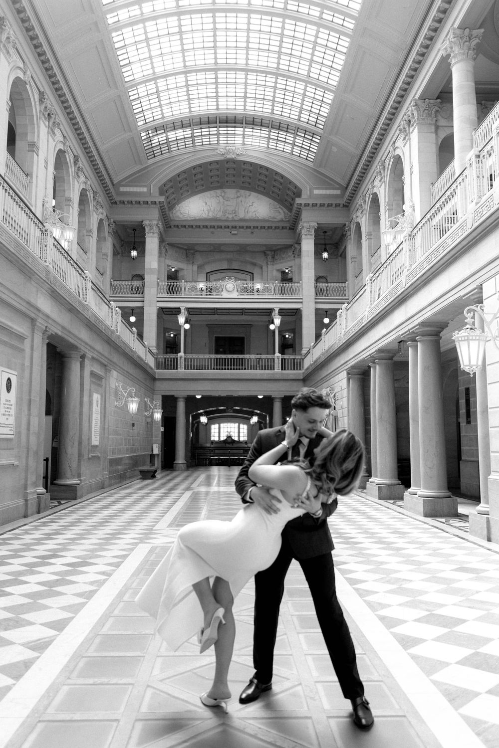 A romantic dip pose captured in a beautiful marble hall with classical architecture.