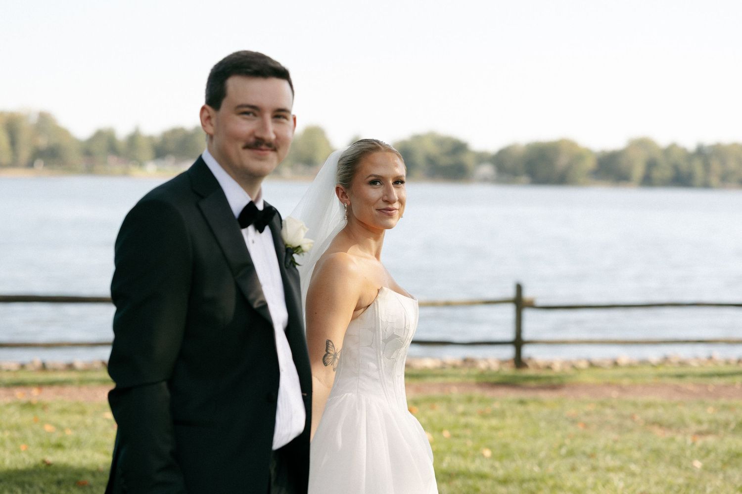 Elegant waterfront wedding photography with formal attire and natural scenery.