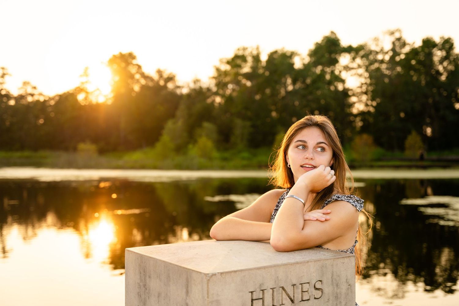 A golden hour portrait session by a lake with a wooden Hines box as a prop.
