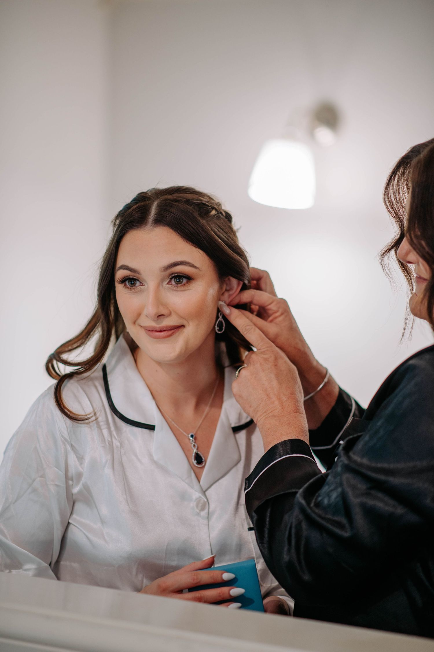 Final touches being added to wedding day hair and jewelry preparation.