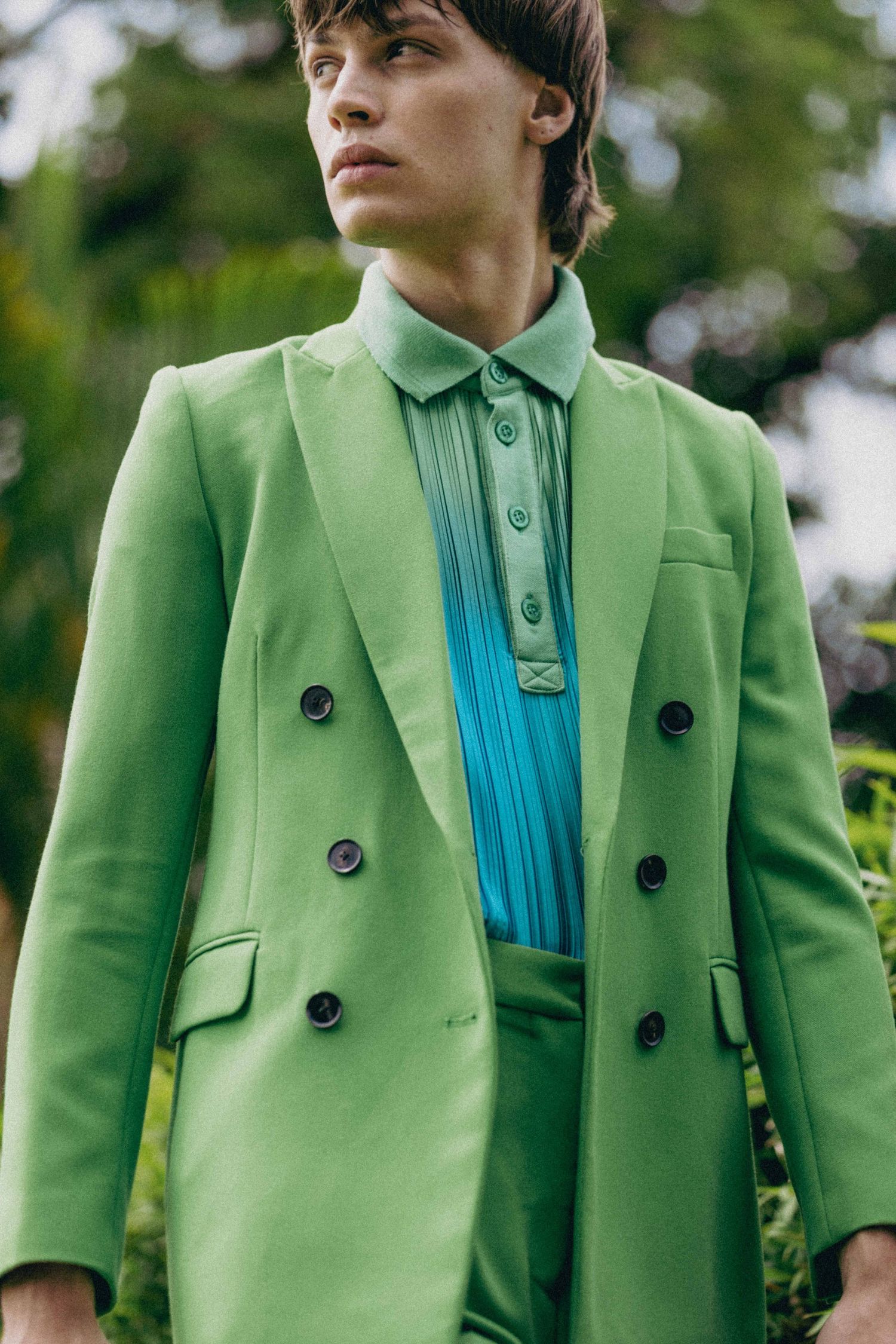 Close-up of green double-breasted suit jacket with turquoise shirt detail.