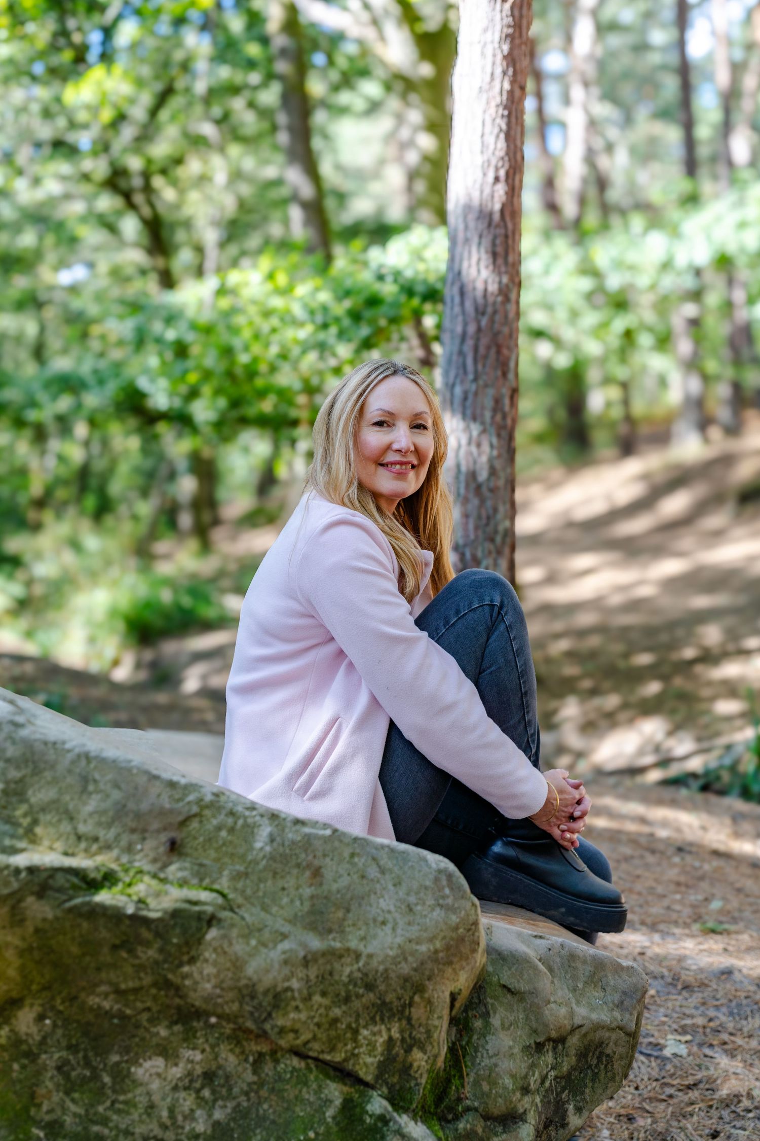 Creative business owner smiling sat on floor with laptop in relaxed branding photography in Kent location