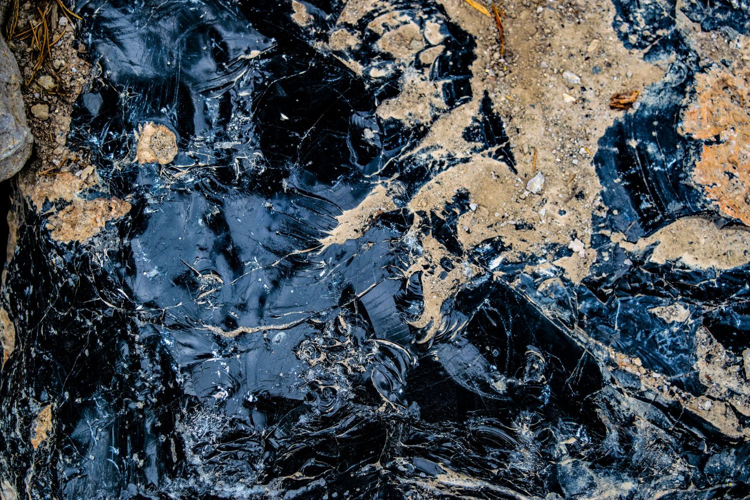 Abstract texture with dark blue and golden tones creating a marbled effect in natural stone.