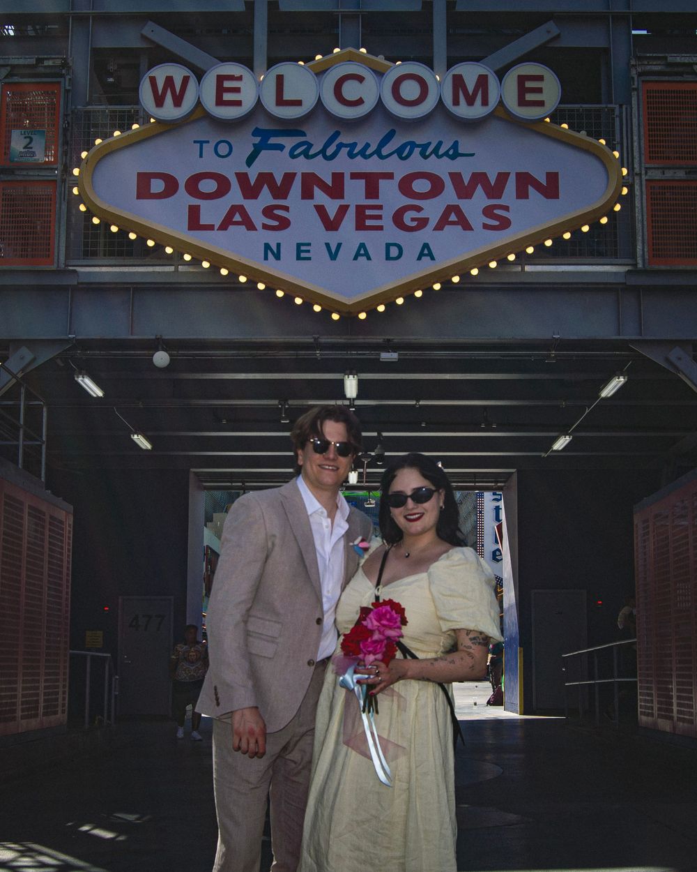 A couple poses under the iconic Welcome to Fabulous Downtown Las Vegas sign.