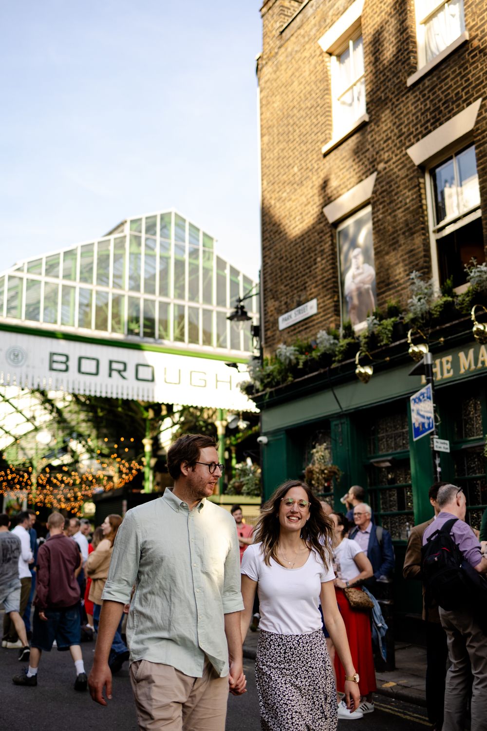 Engaged couple walking through Borough market, London