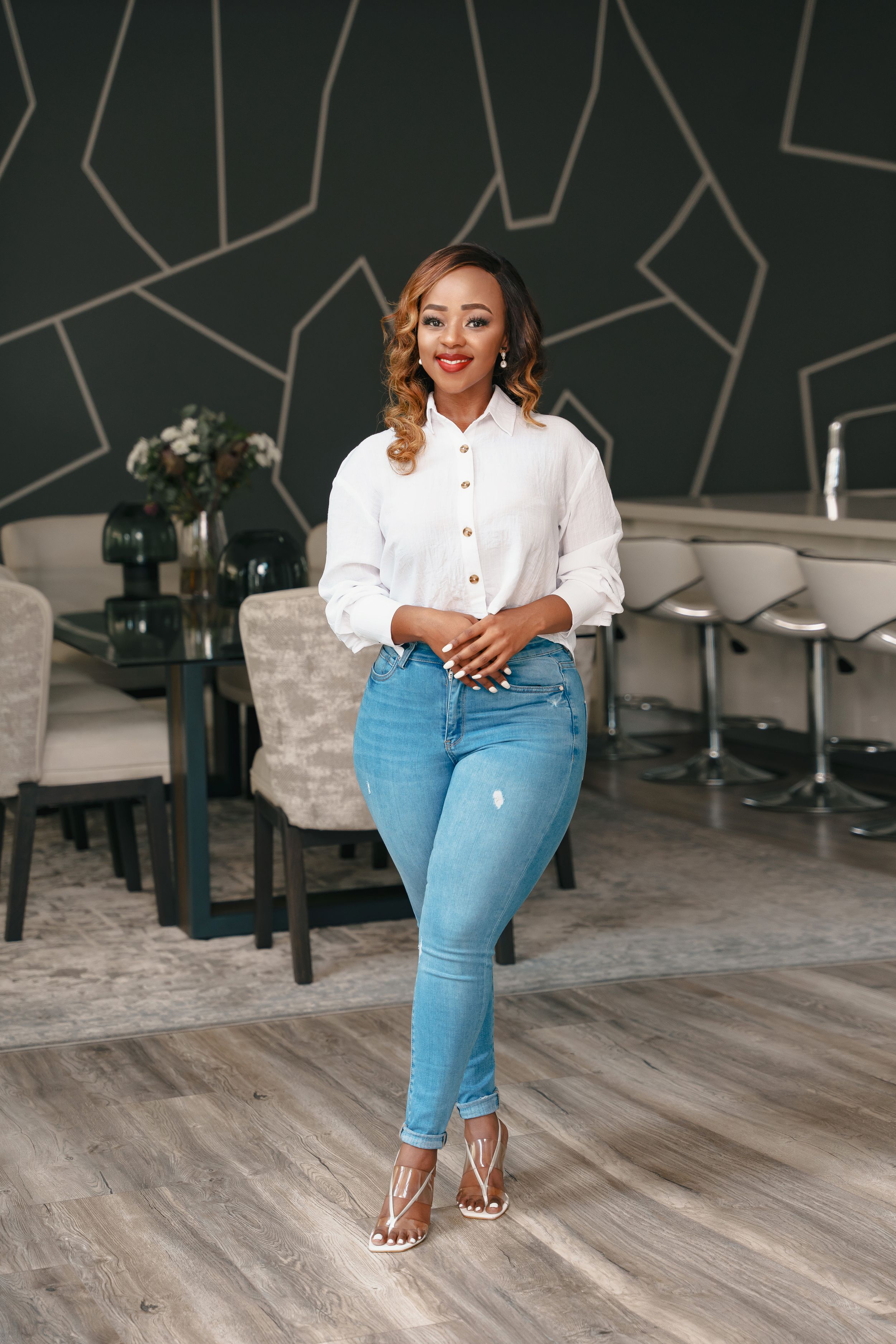 A casual chic outfit featuring a white button-down shirt, distressed jeans, and metallic heels.