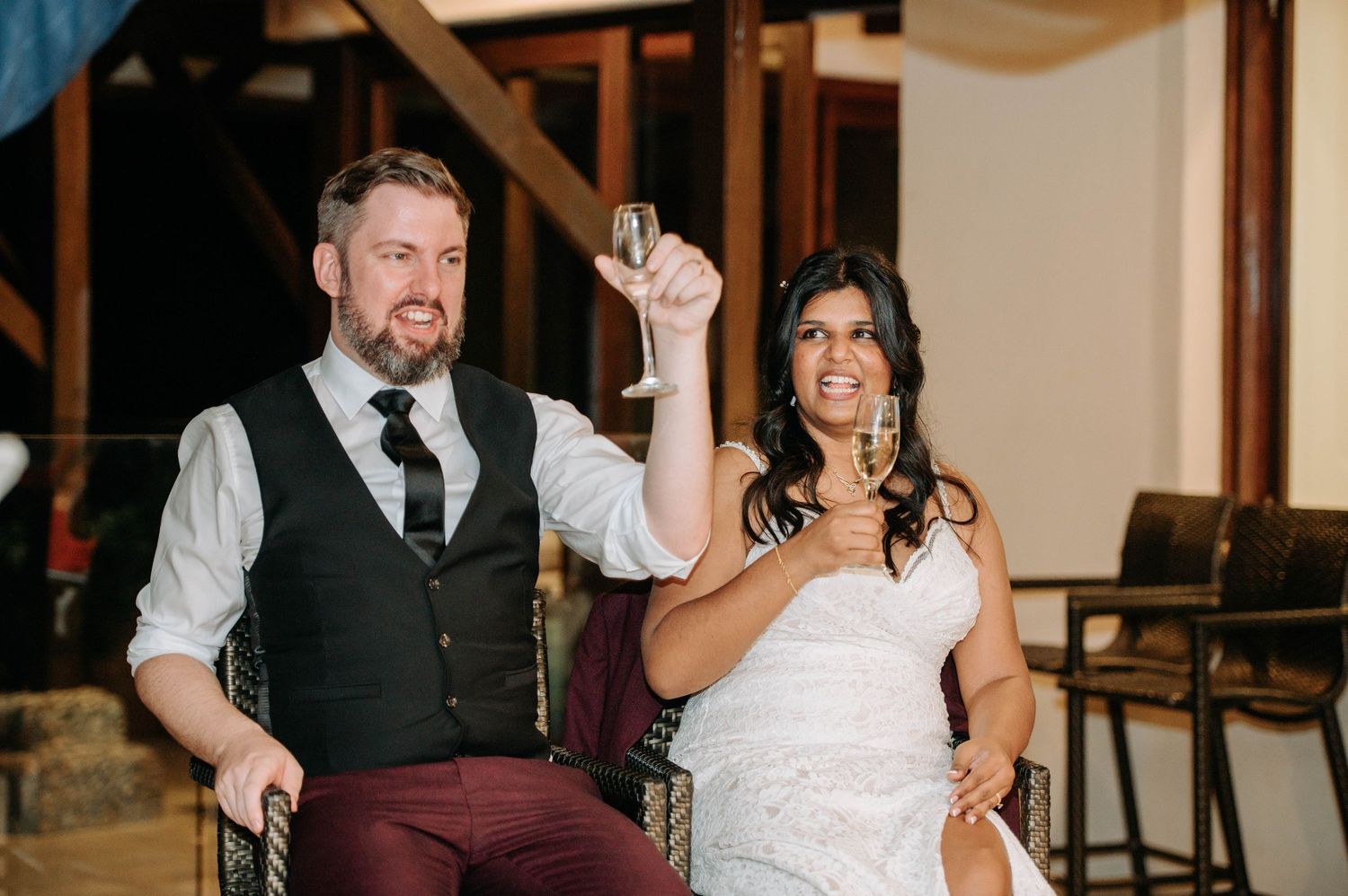 A couple raises their glasses in celebration during their wedding reception.