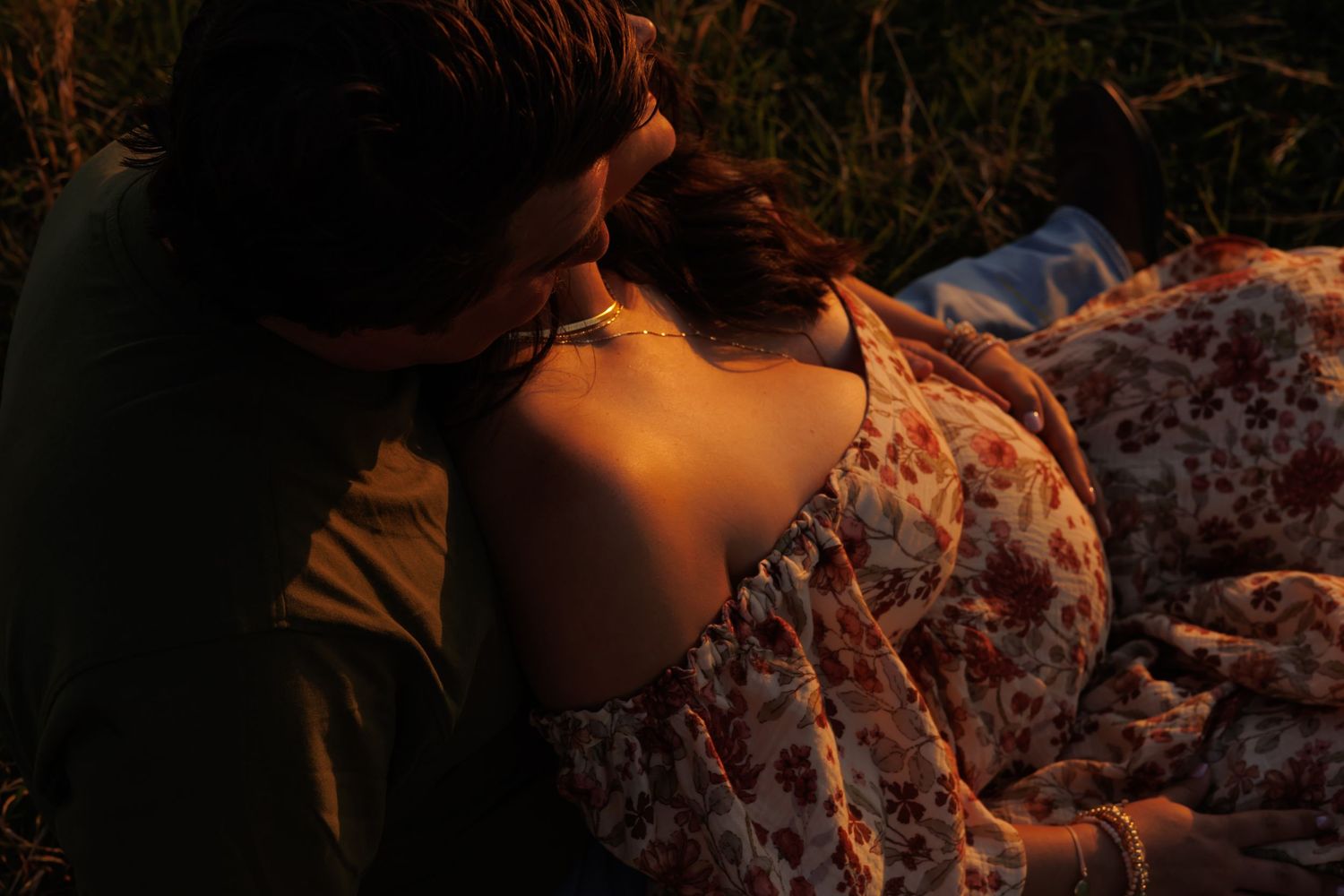 A romantic sunset scene in a field with golden light and flowing fabric.