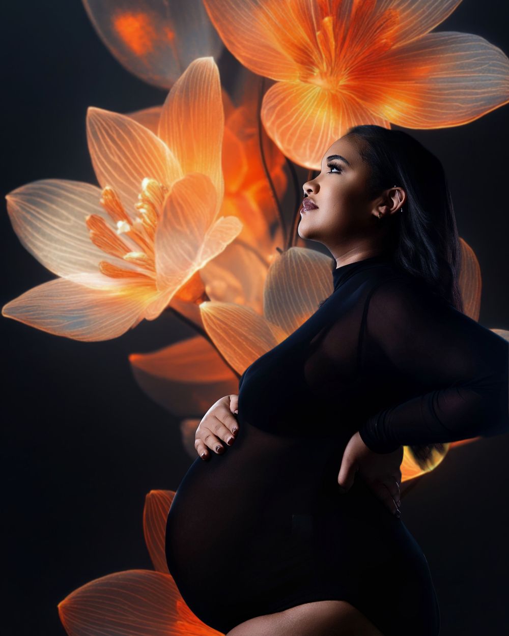 Dark artistic portrait with glowing orange lilies surrounding a silhouetted figure in a black dress against dark background.