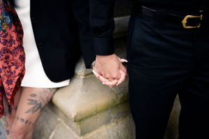 Romantic close-up of a couple holding hands, with  vintage fashion—capturing love, style, and heartfelt moments.