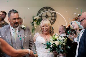 Joyful wedding celebration with a laughing bride and groom, surrounded by confetti and flowers—capturing love, happiness, and new beginnings