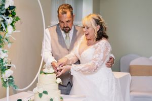 Bride and groom cut their elegant wedding cake—capturing a sweet moment of love and celebration. Perfect for wedding photography inspiration