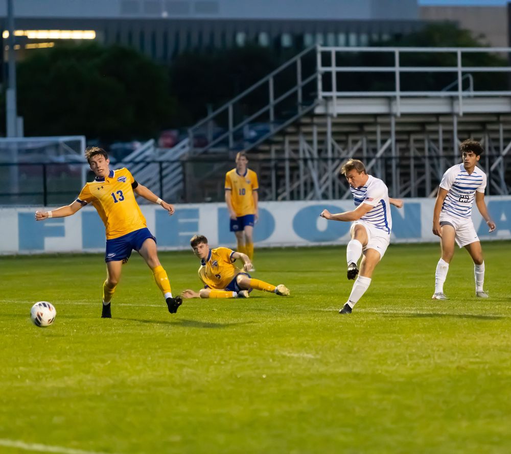 Soccer match action sequence showing players in yellow and white jerseys battling for possession.