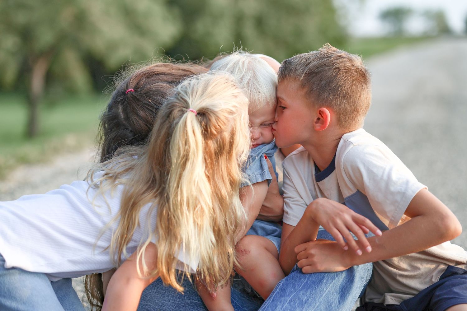 Family shares loving moment outdoors with young child.