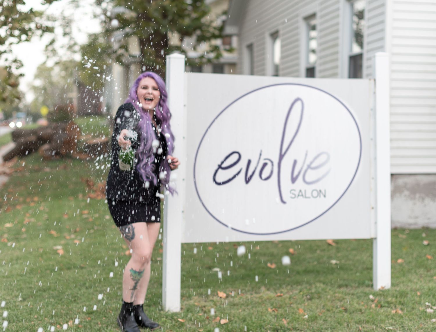 Lincoln, Illinois salon owner laughing while spraying a bottle of champagne during a professional branding session by Julie Loy Photography