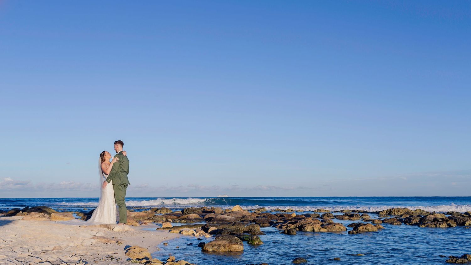 Bride and groom embracing on the beach at The Fives Beach Hotel Riviera Maya during sunset wedding film.