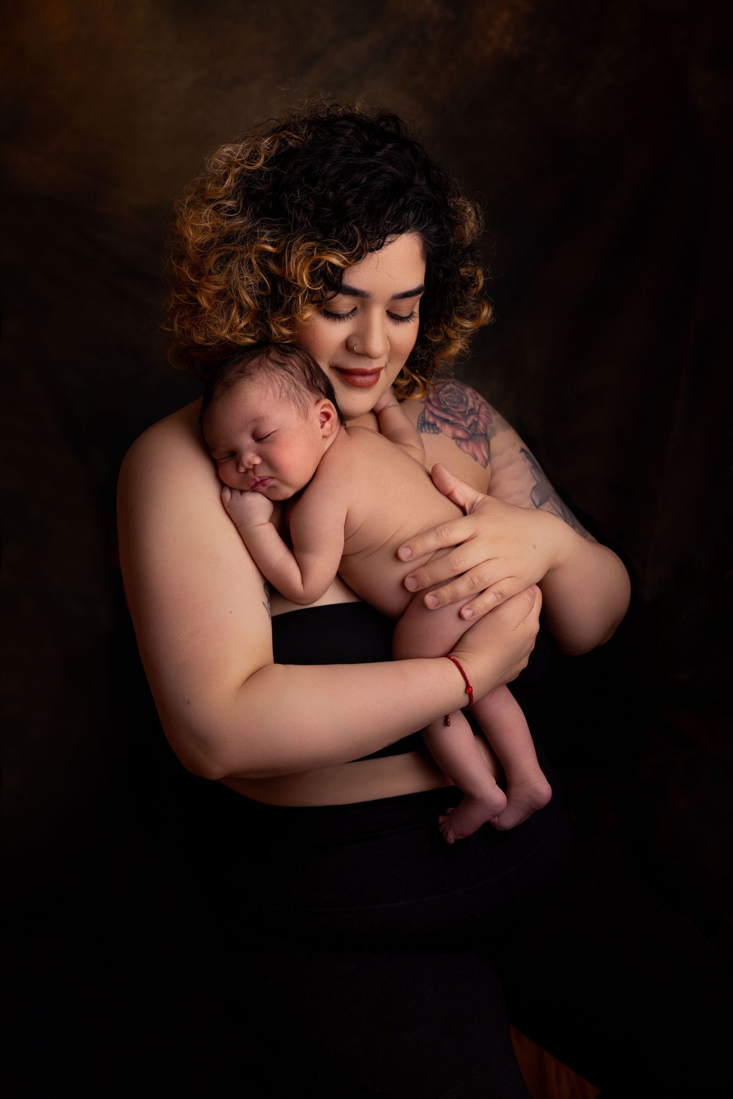 mom holding newborn baby in arms in Portland studio