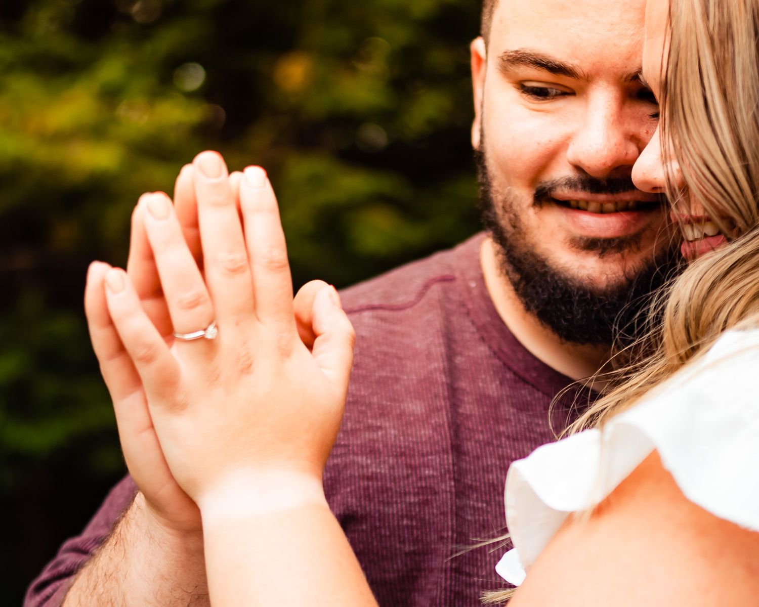 Close-up of hands displaying an engagement ring during a romantic proposal moment.