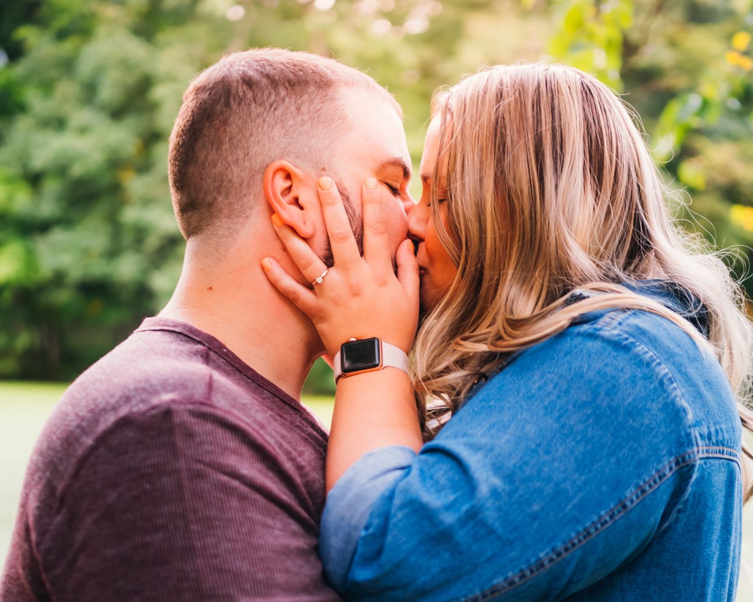 Romantic couple sharing an intimate moment in a sunlit outdoor setting.