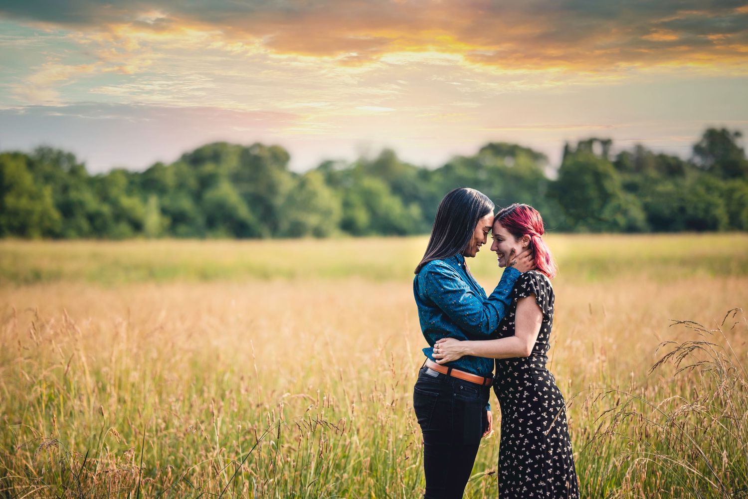 A romantic sunset photoshoot in a golden wheat field with dramatic sky and natural lighting.