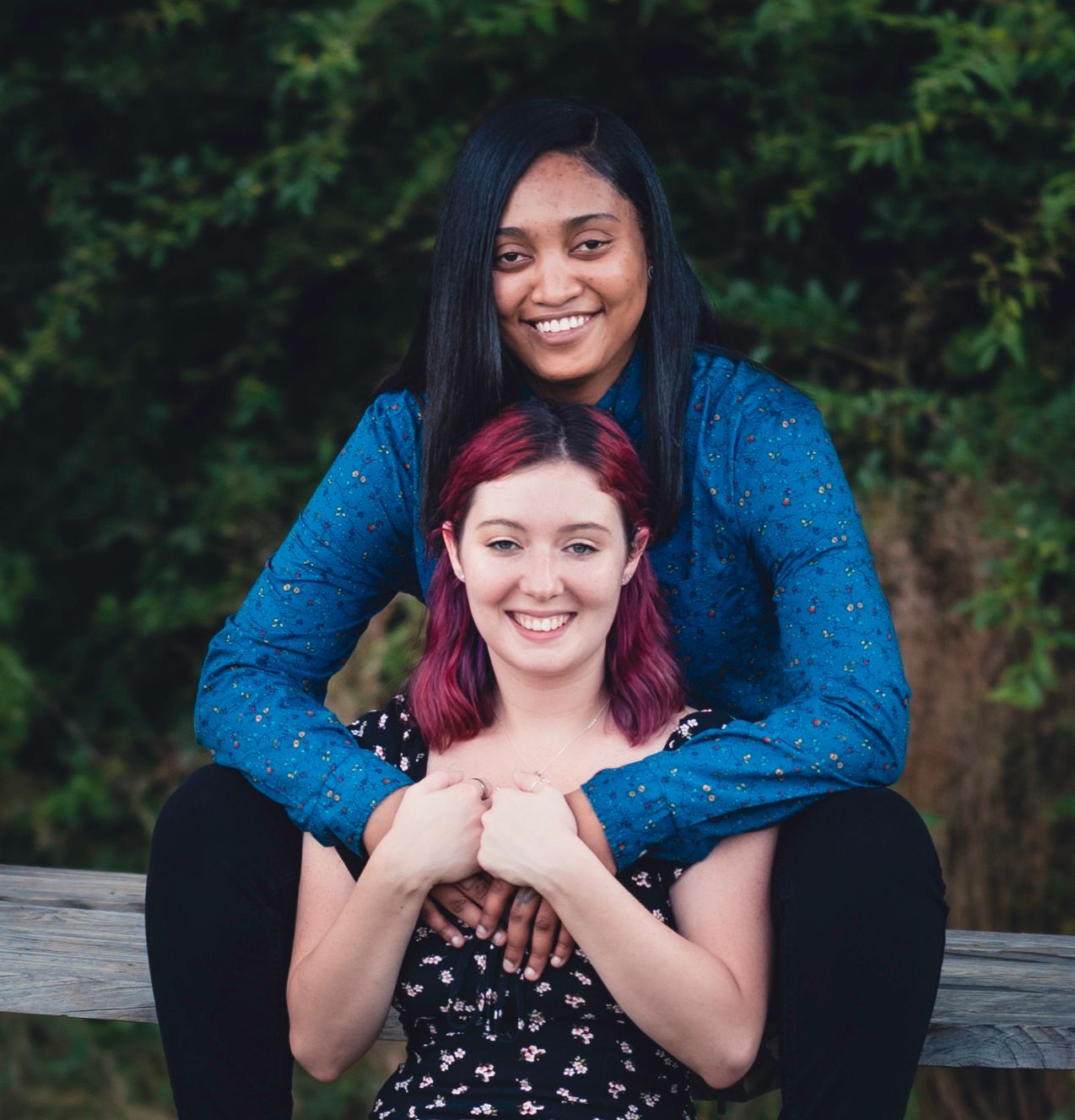 Candid moments captured on a wooden bench during an outdoor photo session.