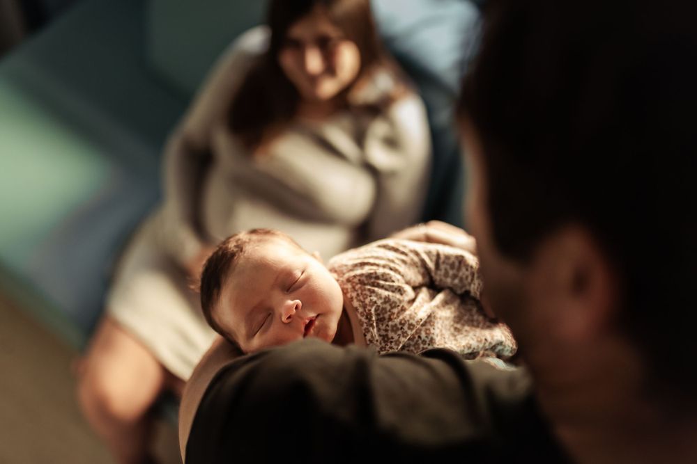 Close-up artistic portrait of sleeping newborn in soft lighting.
