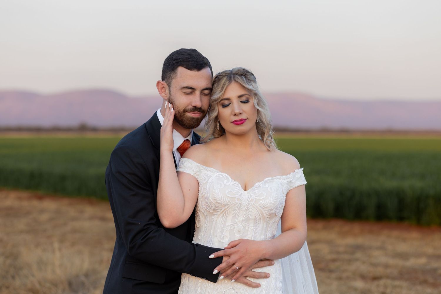 Bride and groom embracing during wedding portraits in Centurion with natural, romantic style and open countryside views