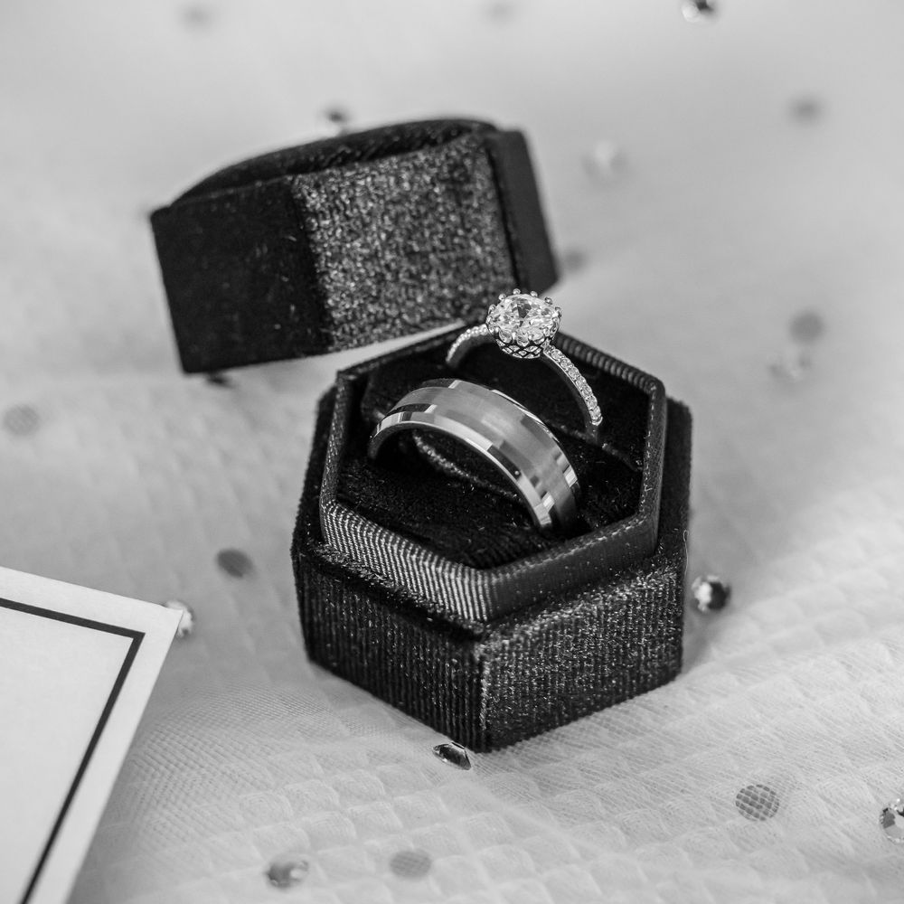 Close-up black and white photos of engagement rings in jewelry boxes.