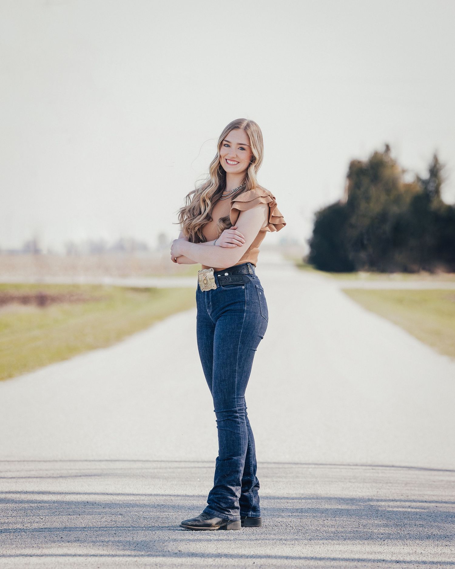Senior posed on road with arms crossed