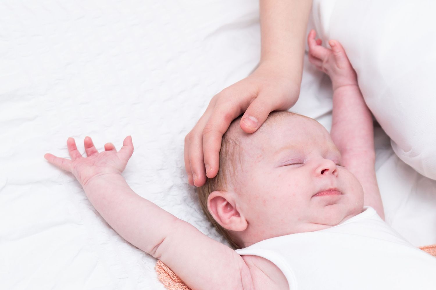 Baby massage demonstration on a white background showing gentle techniques and movements.