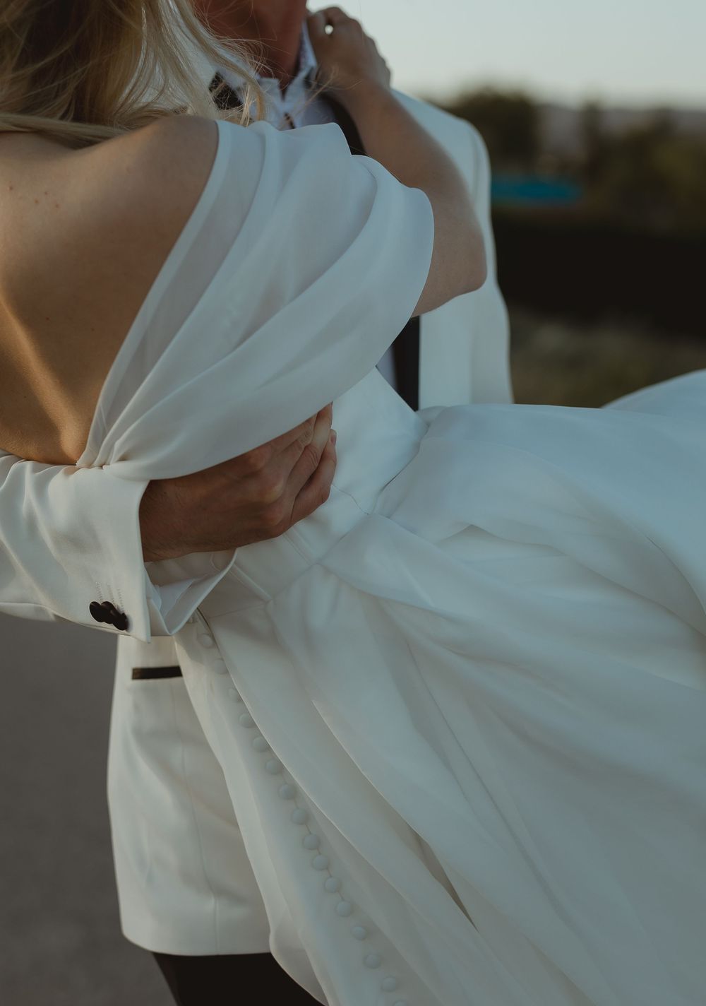 A flowing white wedding dress billows in the breeze, creating elegant movement and graceful fabric ripples.
