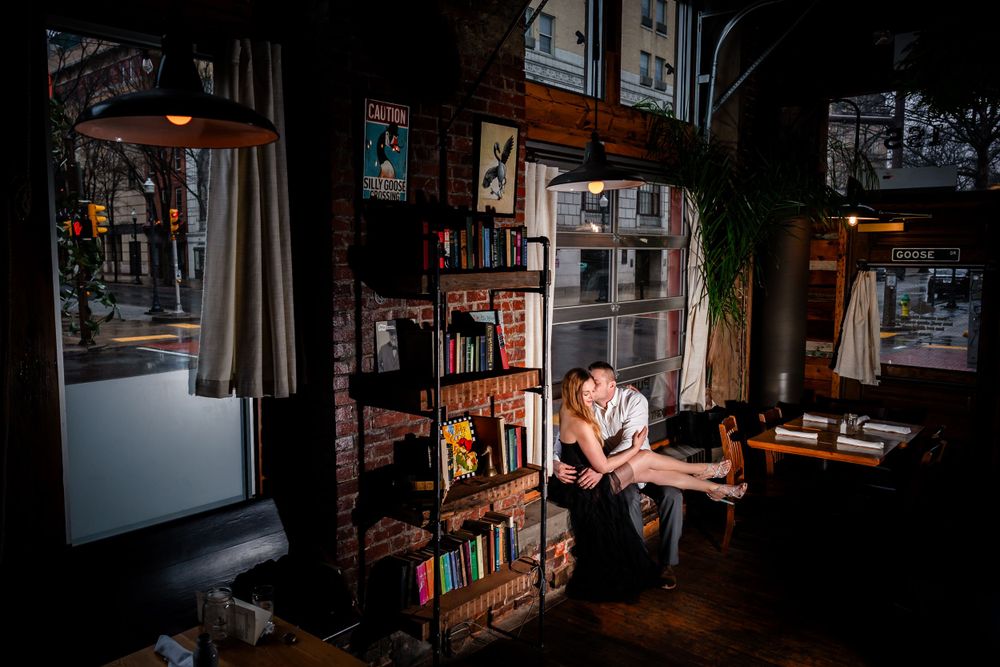 Romantic scene in a cozy library setting with dramatic lighting and bookshelves.