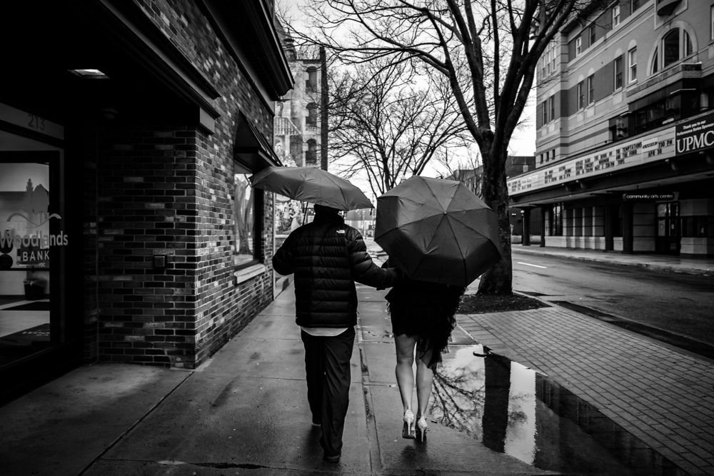 Black and white street scene with umbrella and urban architecture.