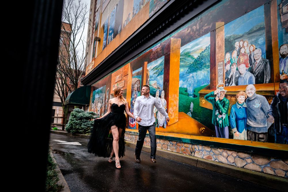 An intimate photo session along a wall decorated with colorful street murals.