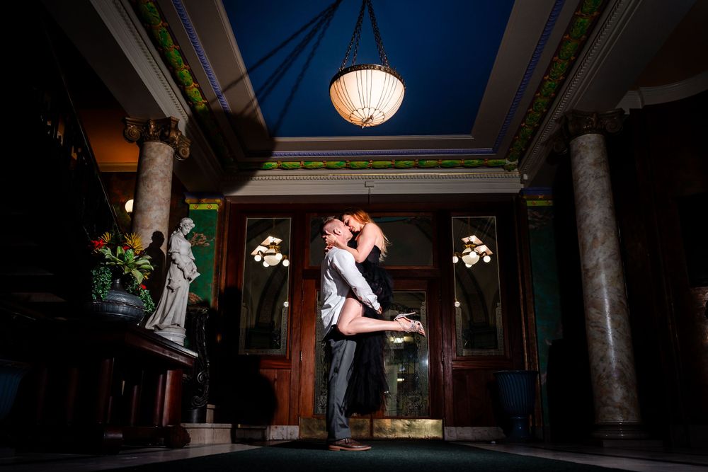 A romantic silhouette against dramatic lighting in an elegant indoor space.