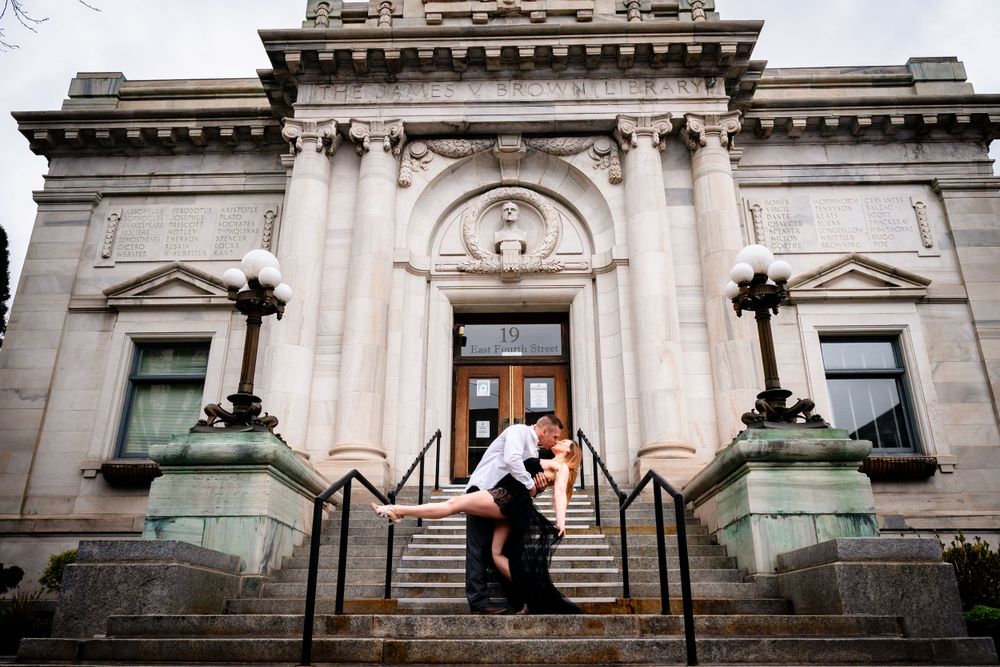 A romantic photo session on the steps of a grand classical stone building.