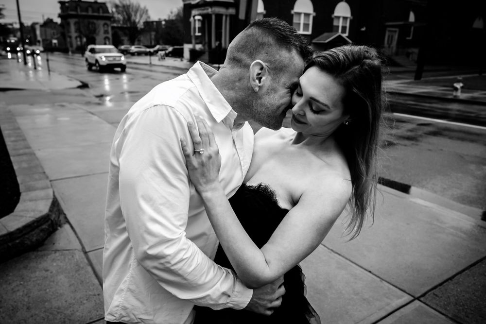 A black and white street photography moment capturing an intimate embrace.